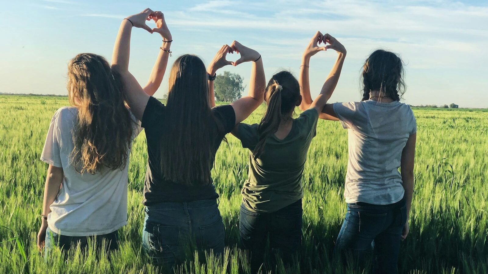 women forming heart gestures during daytime